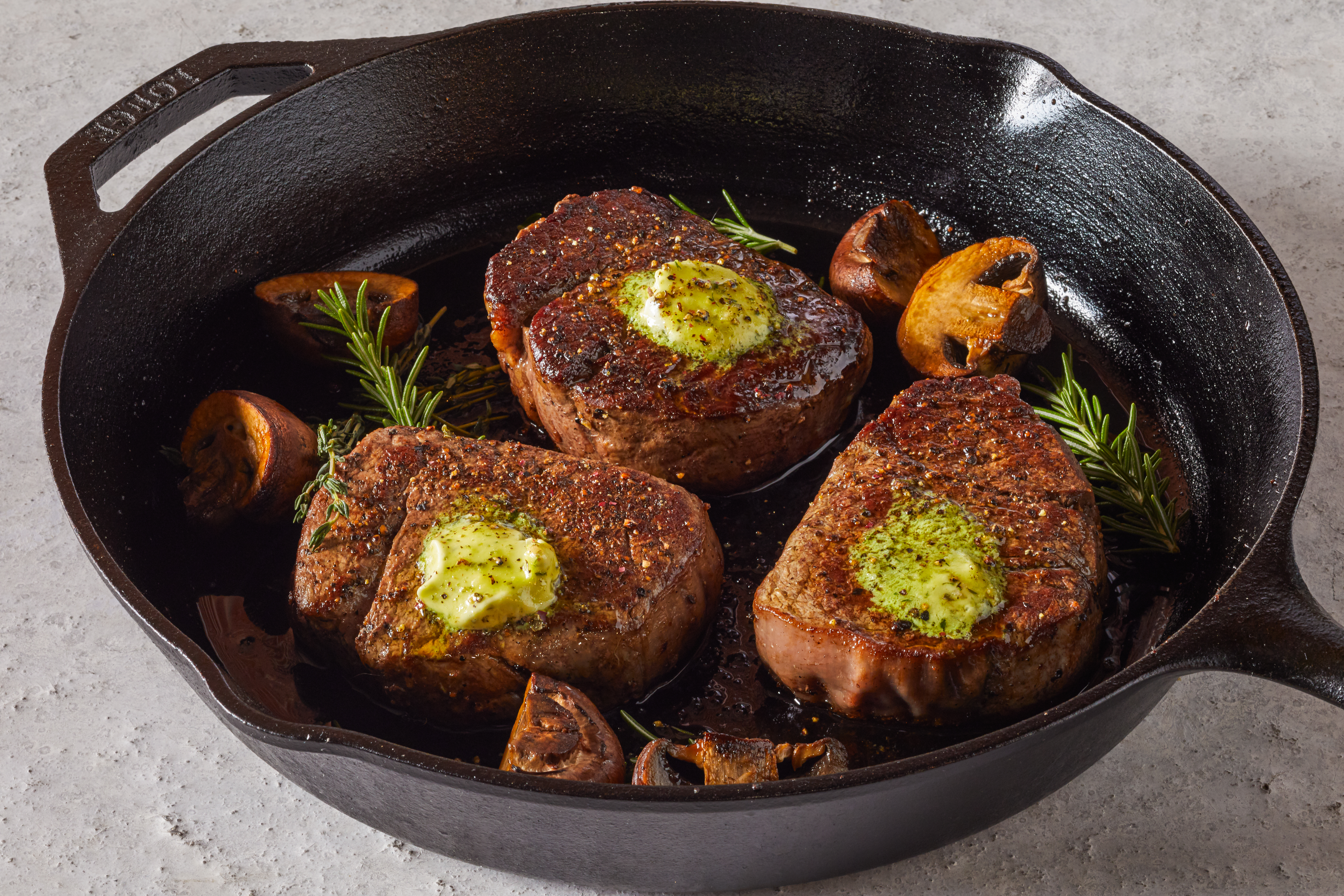 filet mignon in a skillet with mushrooms 