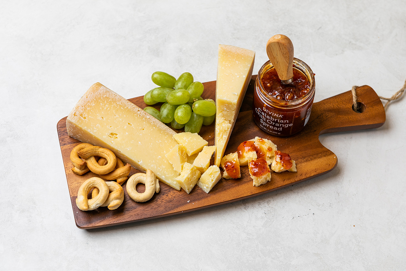 cheese, grapes and other snacks on a cutting board