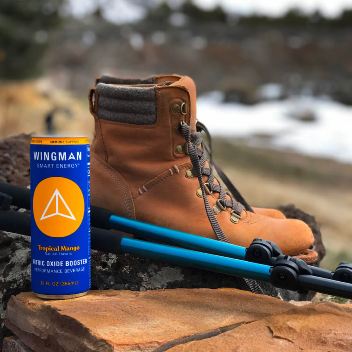 Wingman drink next to hiking boot and gear