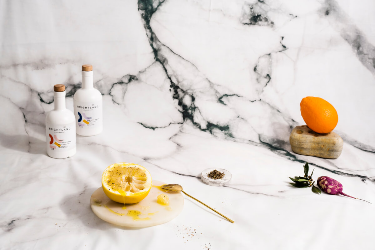 Bottles of olive oil and half a lemon 