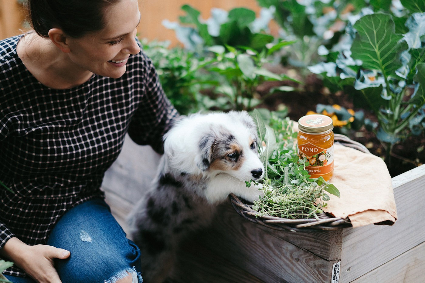 Alysa with a jar of bone broth and a dog