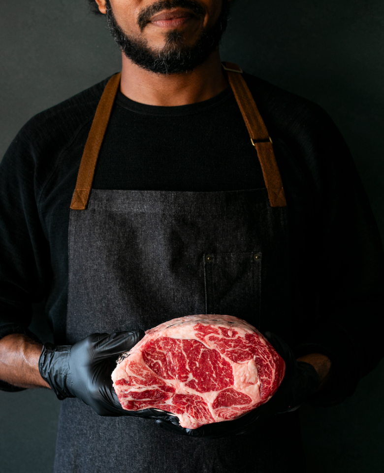 man holding raw steak