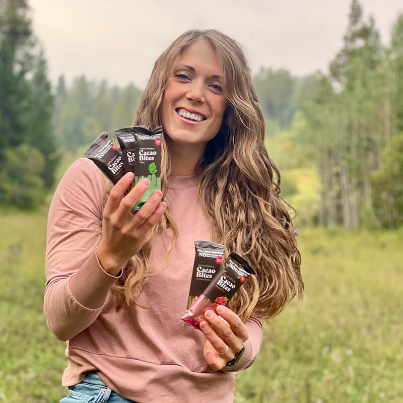 Founder Kelsi Petersen holding packs of cacao bites