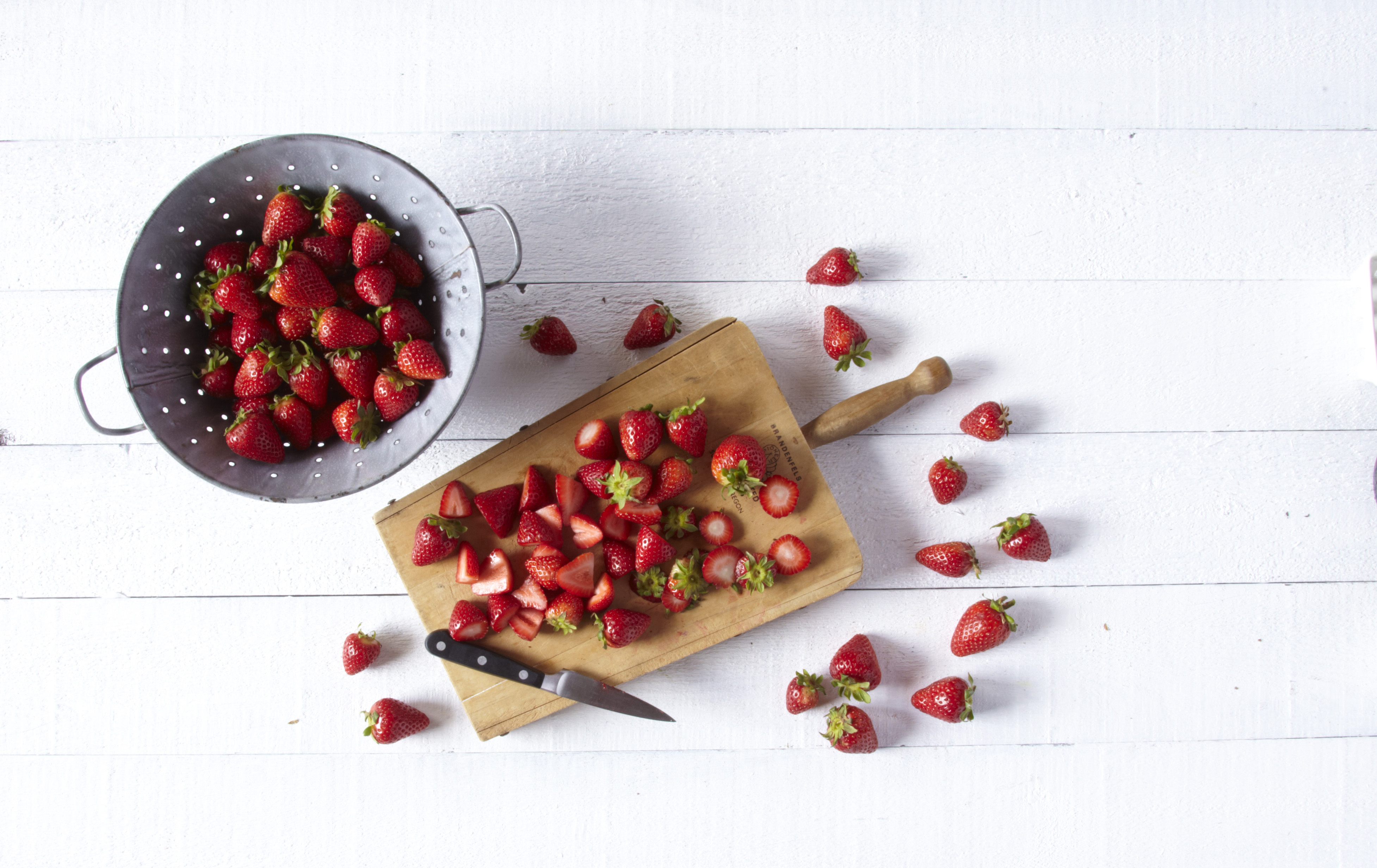 colander and cutting board with strawberries