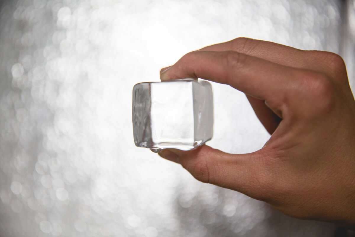 hand holding a cube of penny pound ice