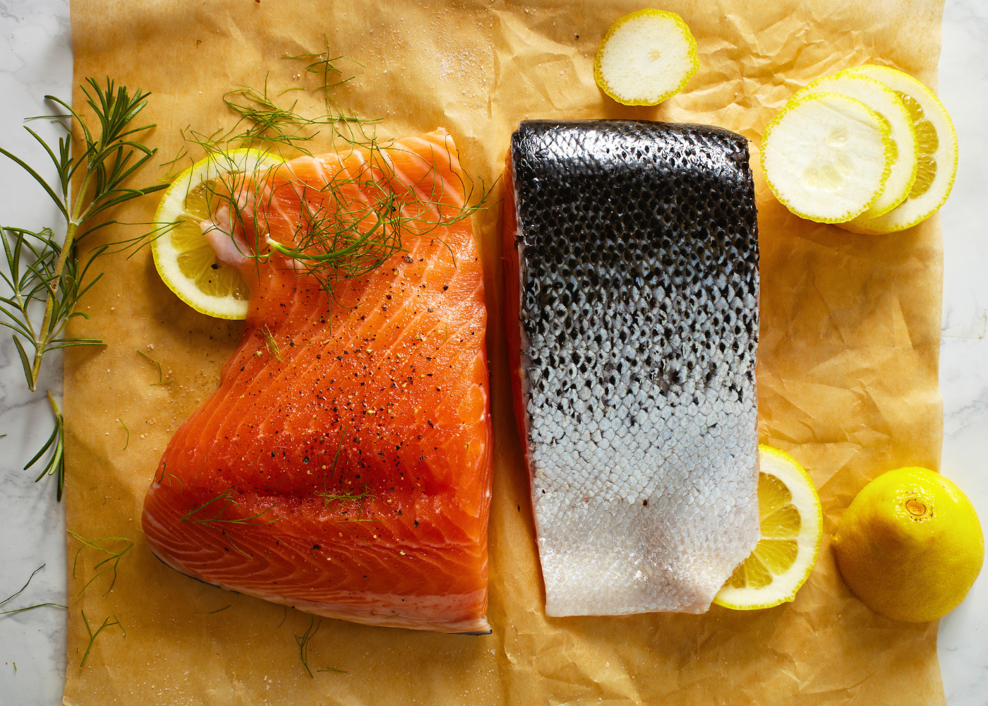 two salmon fillets with lemon and dill laying on table