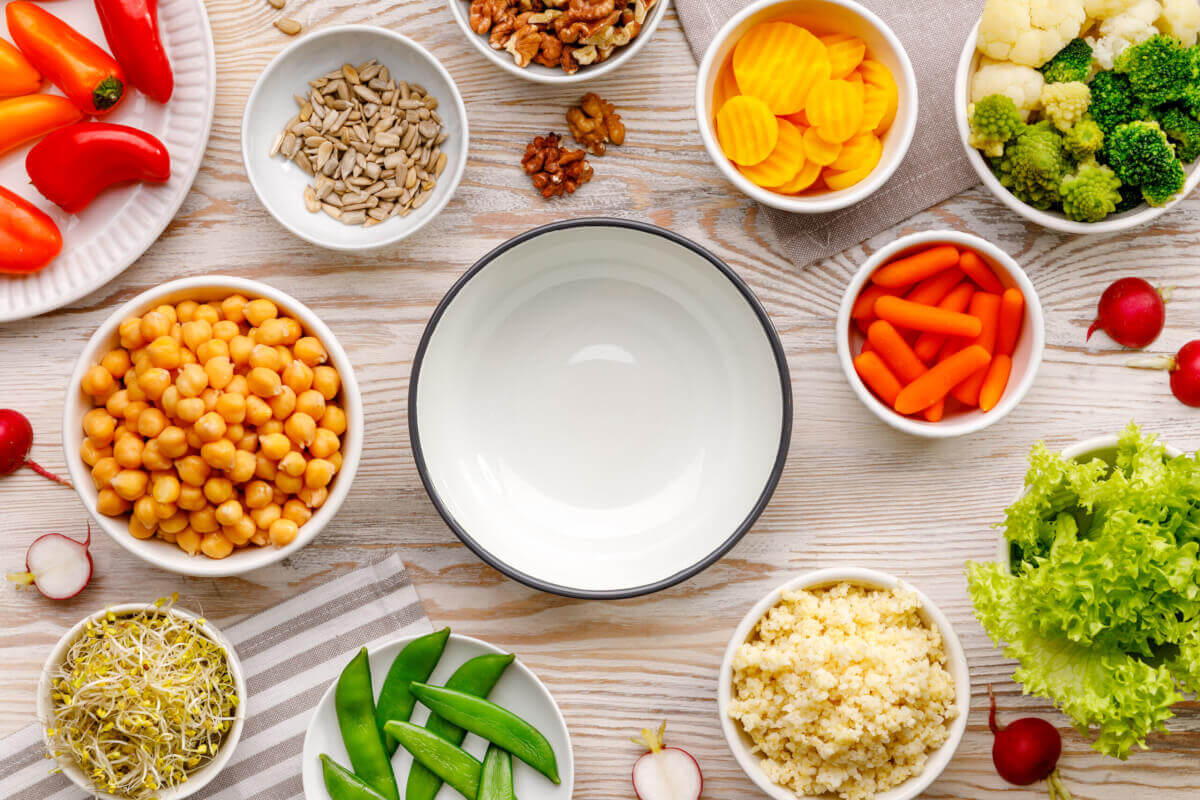 empty bowl surrounded by bowls of vegetables and grains