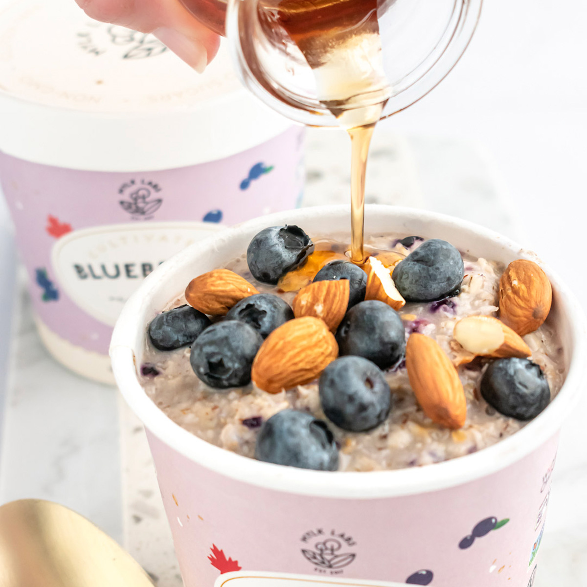container of oatmeal with blueberries and almonds on top