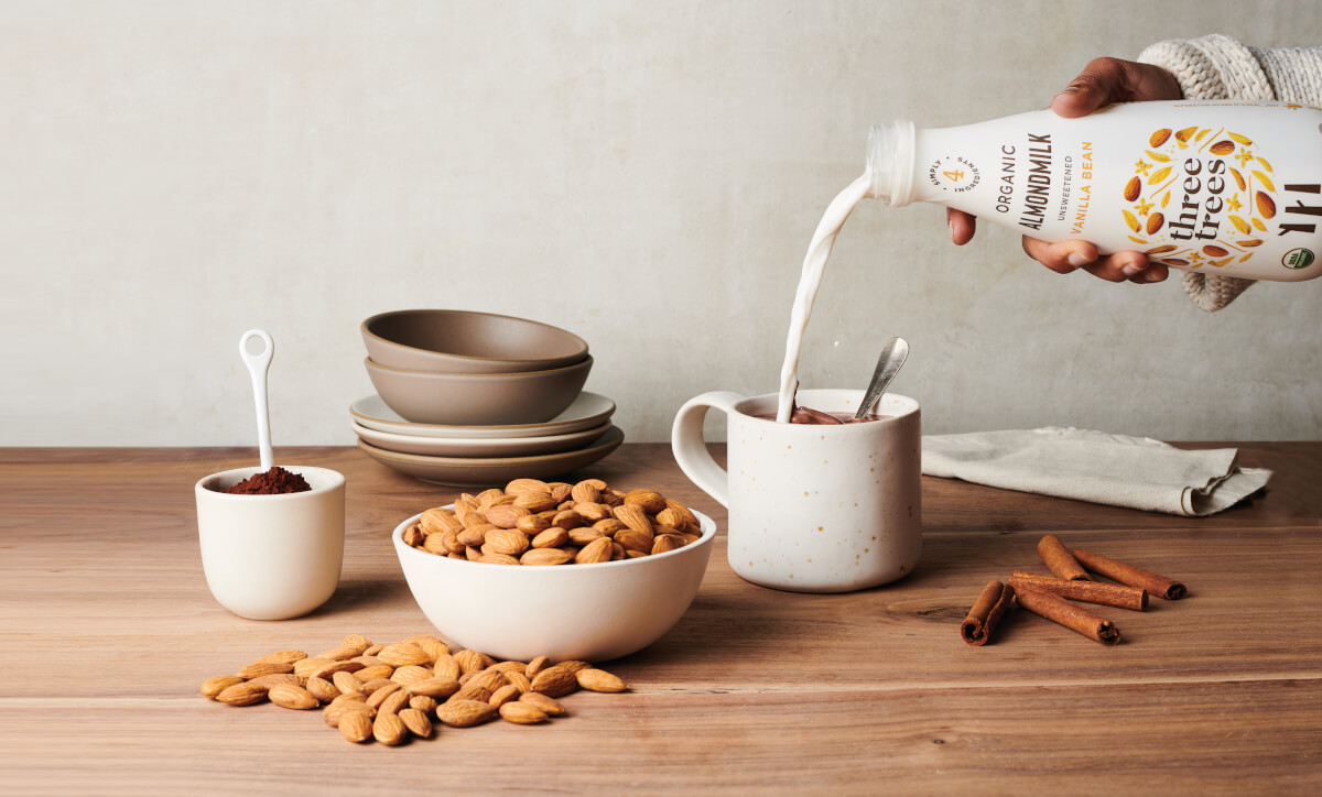 Bottle of almond milk being poured into a mug