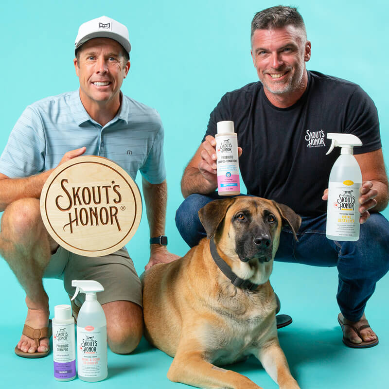 Brock and Stirling posing with a dog and Skout's Honor products
